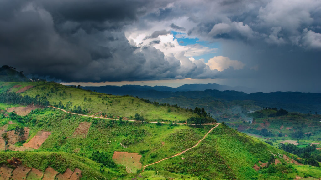 A view of the sky from above a green hill.