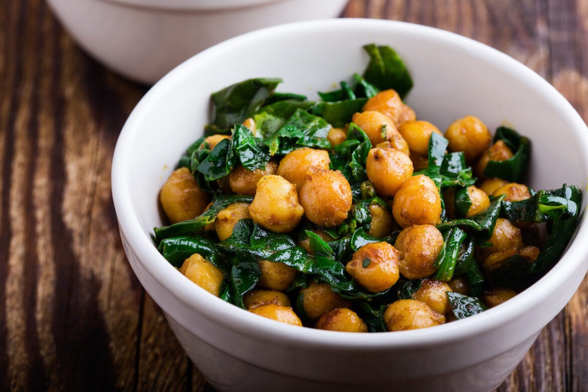 A bowl of Guyanese channa and spinach on top of a table.