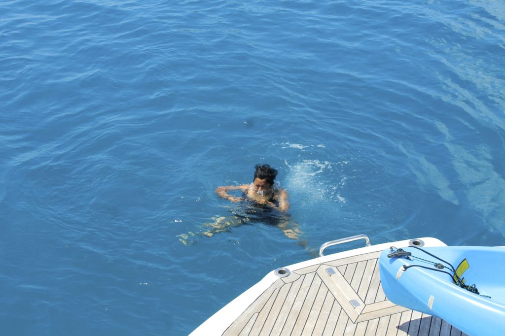 A person swimming in the water on a boat. Bawah Private Island