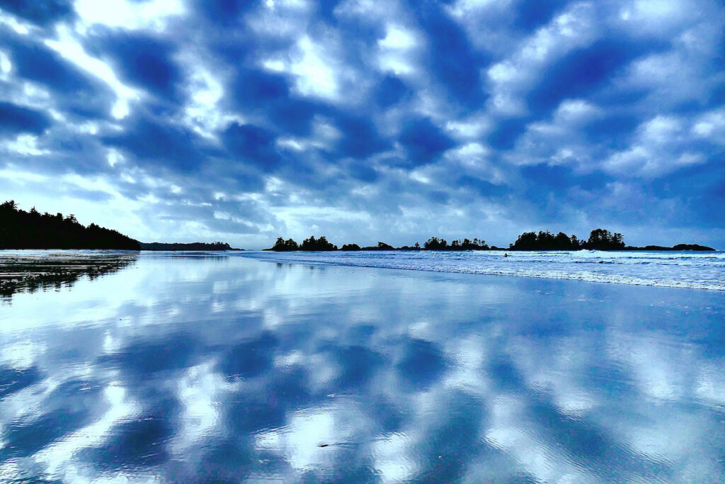 A body of water with clouds in the sky.
