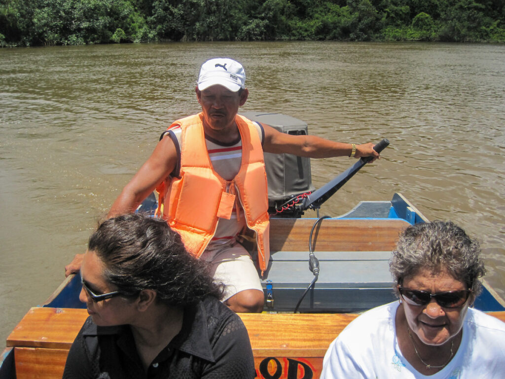 A man in an orange life vest is on the boat.