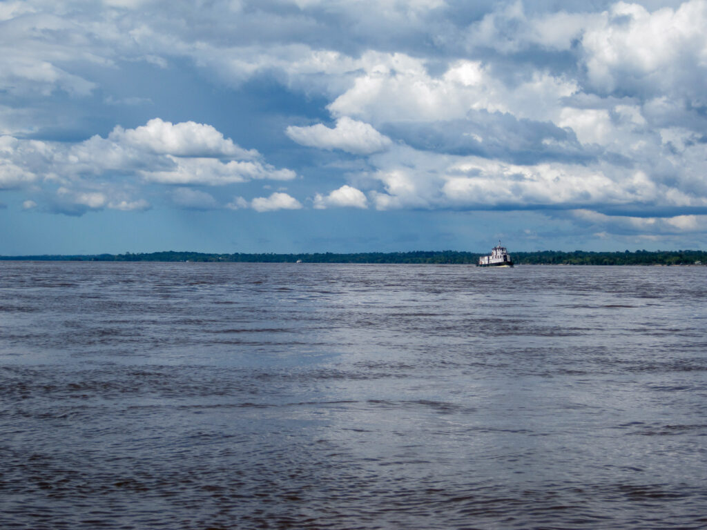 A boat is in the water near some clouds.