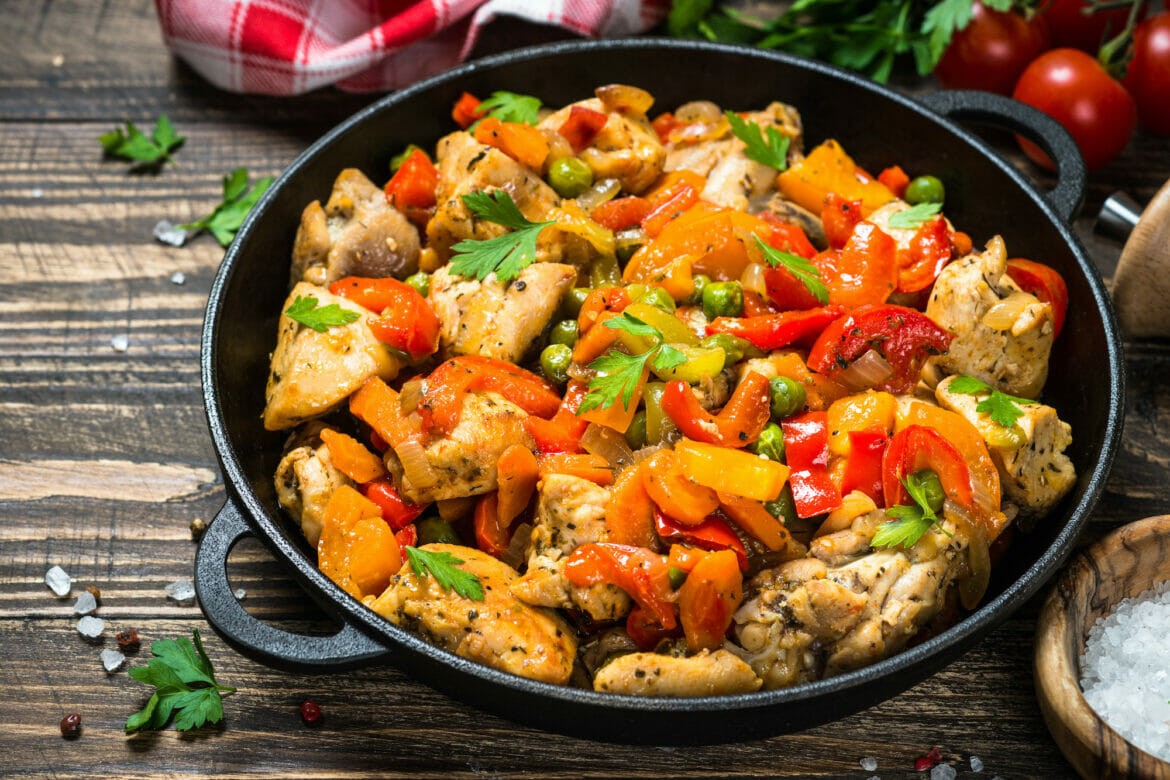 A pan of food with chicken and peppers.
