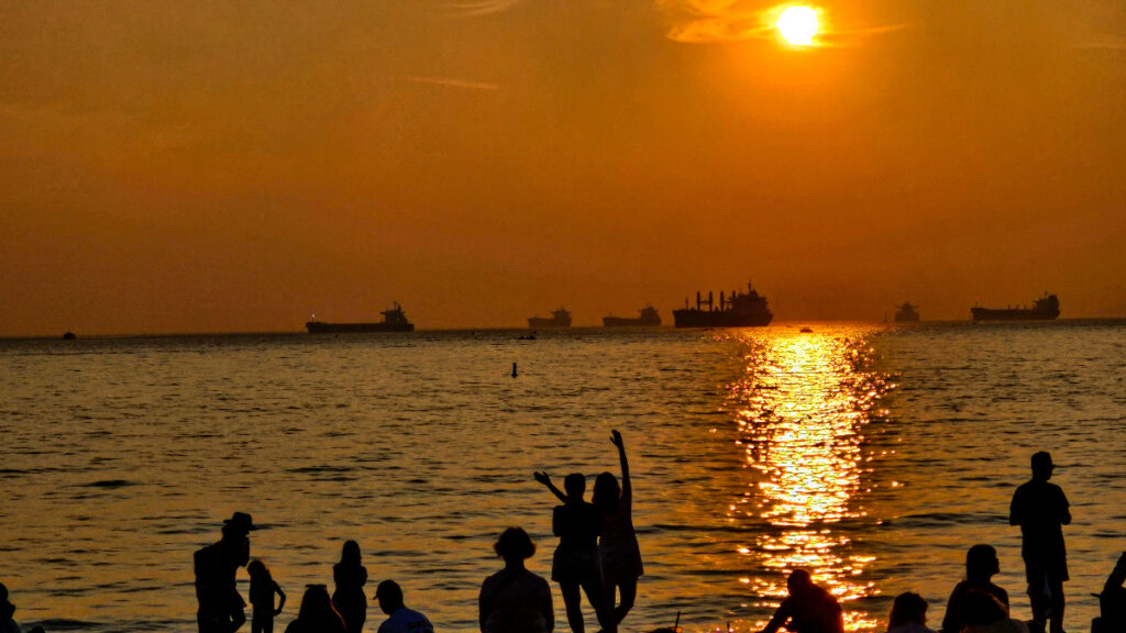 women in silhouette on the beach at sunset.