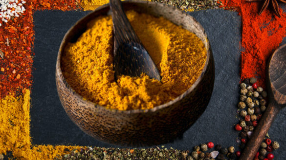 A bowl of turmeric is sitting on the ground.