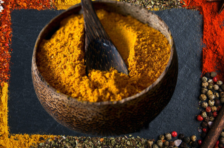 A bowl of turmeric is sitting on the ground.