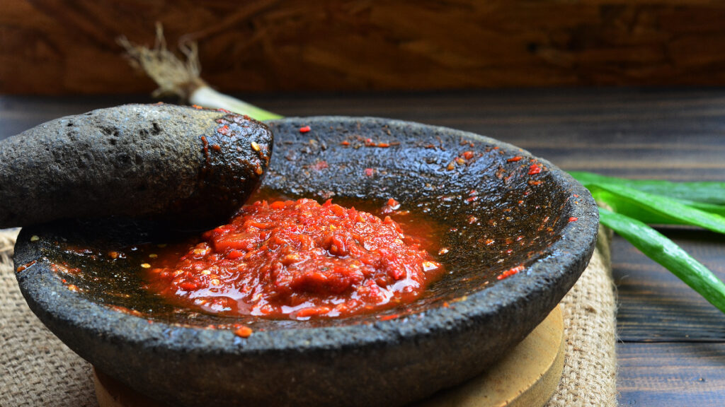 A bowl of sauce is being prepared in the kitchen.