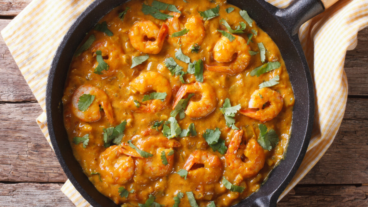 A pan of shrimp and rice with cilantro.