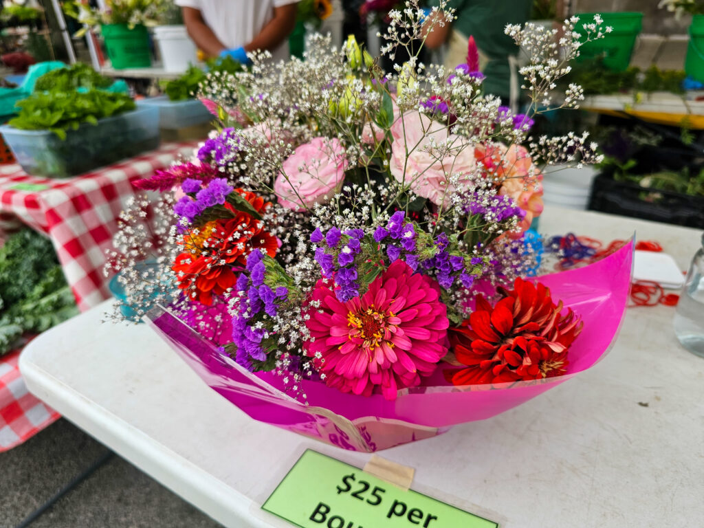 A bouquet of flowers in a bowl on top of a table.